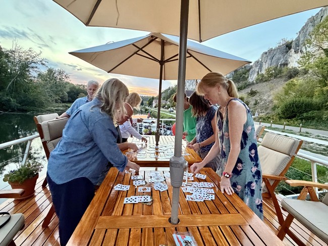 Family playing cards on the Luciole sundeck