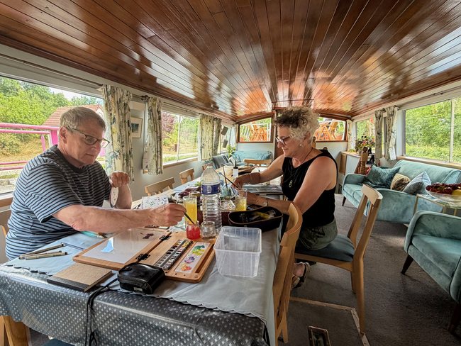Art Cruise guests painting in the saloon aboard Luciole